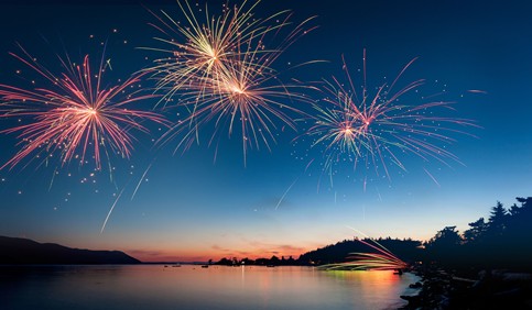 firework display over river during sunset